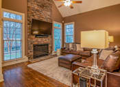 Thumbnail 16 of 21 - A living room with a fireplace and a couch.