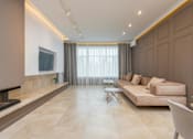 Thumbnail 2 of 5 - A modern living room with a fireplace and a large couch.