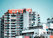 Thumbnail 5 of 8 - A tall building with a red top stands out against a clear sky.