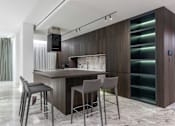 Thumbnail 9 of 9 - A modern kitchen with a bar area and grey chairs.