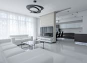 Thumbnail 8 of 9 - A modern living room with white furniture and a large window.