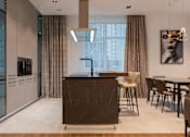 Thumbnail 2 of 9 - A modern kitchen with a dark brown island and chairs.