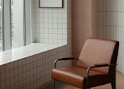 Thumbnail 1 of 9 - A brown leather chair sits in front of a window with a white frame and a picture on the wall.