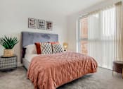 Thumbnail 2 of 7 - a bedroom with a bed and a large window
