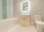 Thumbnail 8 of 10 - a bathroom with a toilet and a sink and a bath tub