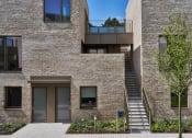 Thumbnail 2 of 29 - a large brick building with a staircase and a balcony