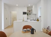 Thumbnail 6 of 29 - a kitchen with white walls and white countertops and a white island with a white countertop