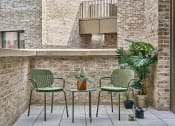 Thumbnail 1 of 29 - a patio with two green chairs and a small table with a plant on it