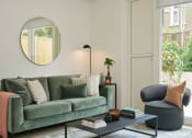 Thumbnail 17 of 29 - a living room with a green couch and a blue chair