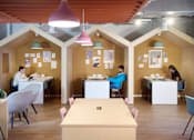 Thumbnail 6 of 35 - A group of people are sitting at tables in a room with a wooden floor and ceiling.