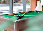 Thumbnail 15 of 35 - A pool table with a green cloth and a white cue ball.