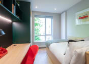 Thumbnail 8 of 18 - a bedroom with a bed and a desk and a window