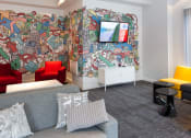 Thumbnail 3 of 16 - a living room with a mural on the wall and a couch