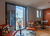 Thumbnail 26 of 36 - A living room with a view of the city through the window.