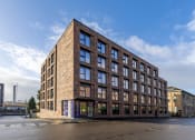 Thumbnail 15 of 15 - a brick building with many windows and a blue sky