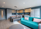 Thumbnail 3 of 18 - a kitchen and living room with a blue couch