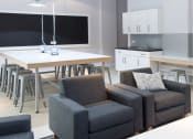 Thumbnail 6 of 16 - a living room and kitchen with chairs and a table and a tv