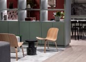 Thumbnail 3 of 20 - a living room with two chairs and a table and a kitchen in the background