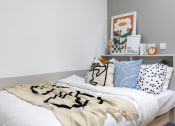Thumbnail 22 of 35 - a bedroom with a bed with a black and white comforter and pillows