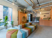 Thumbnail 1 of 35 - a seating area with colorful cushions in front of a large window in an office