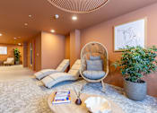 Thumbnail 2 of 65 - A living room with a chair, a table, and a plant.