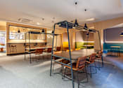 Thumbnail 13 of 36 - A modern dining area with a long table and chairs.
