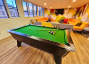 Thumbnail 2 of 13 - a game room with a pool table and orange couches