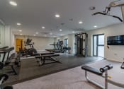 Thumbnail 13 of 37 - a gym with exercise equipment and a tv