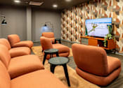 Thumbnail 25 of 36 - a living room with couches and chairs and a television