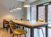 Thumbnail 16 of 36 - A conference room with a long table and chairs.