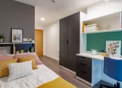 Thumbnail 14 of 21 - a bedroom with a bed and a desk and a closet