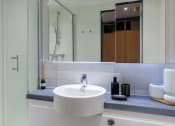 Thumbnail 18 of 19 - a modern bathroom with a sink and a mirror
