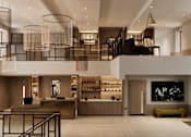 Thumbnail 2 of 26 - A modern interior space with a bar area and a staircase.