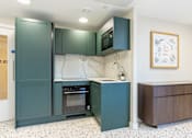 Thumbnail 57 of 65 - A kitchen with green cabinets and a fridge.