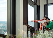Thumbnail 42 of 54 - A man and woman are standing by a window with a view of the city.