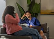 Thumbnail 21 of 54 - A man and a woman are sitting on a couch with a laptop.