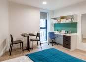 Thumbnail 13 of 21 - a bedroom with a desk and a chair and a bed