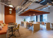 Thumbnail 5 of 35 - a dining room with tables and chairs and a orange accent wall