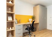 Thumbnail 25 of 35 - A yellow accent wall behind a desk with a black chair.