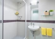 Thumbnail 9 of 16 - a white bathroom with a shower and a sink