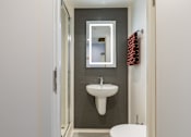 Thumbnail 25 of 35 - A bathroom with a white sink and a white toilet.