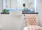 Thumbnail 23 of 35 - A white sink with a red and white towel on a white toilet.