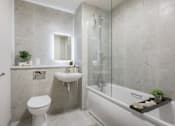 Thumbnail 32 of 38 - A bathroom with a white toilet, a sink, a bathtub, and a mirror.