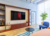 Thumbnail 31 of 41 - A living room with a flat screen TV mounted on the wall.