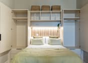 Thumbnail 63 of 65 - A bedroom with a bed, pillows, and shelves above it.