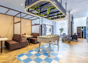 Thumbnail 2 of 41 - A modern room with a table and chairs and a green plant hanging from the ceiling.