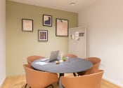 Thumbnail 25 of 35 - a round table with orange chairs and a laptop on it