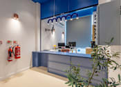 Thumbnail 37 of 41 - A reception area with a blue counter and a plant in the foreground.