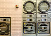 Thumbnail 40 of 41 - Three washing machines are lined up against a brick wall.