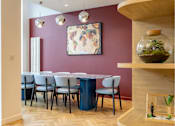 Thumbnail 19 of 41 - A dining room with a purple table and chairs.